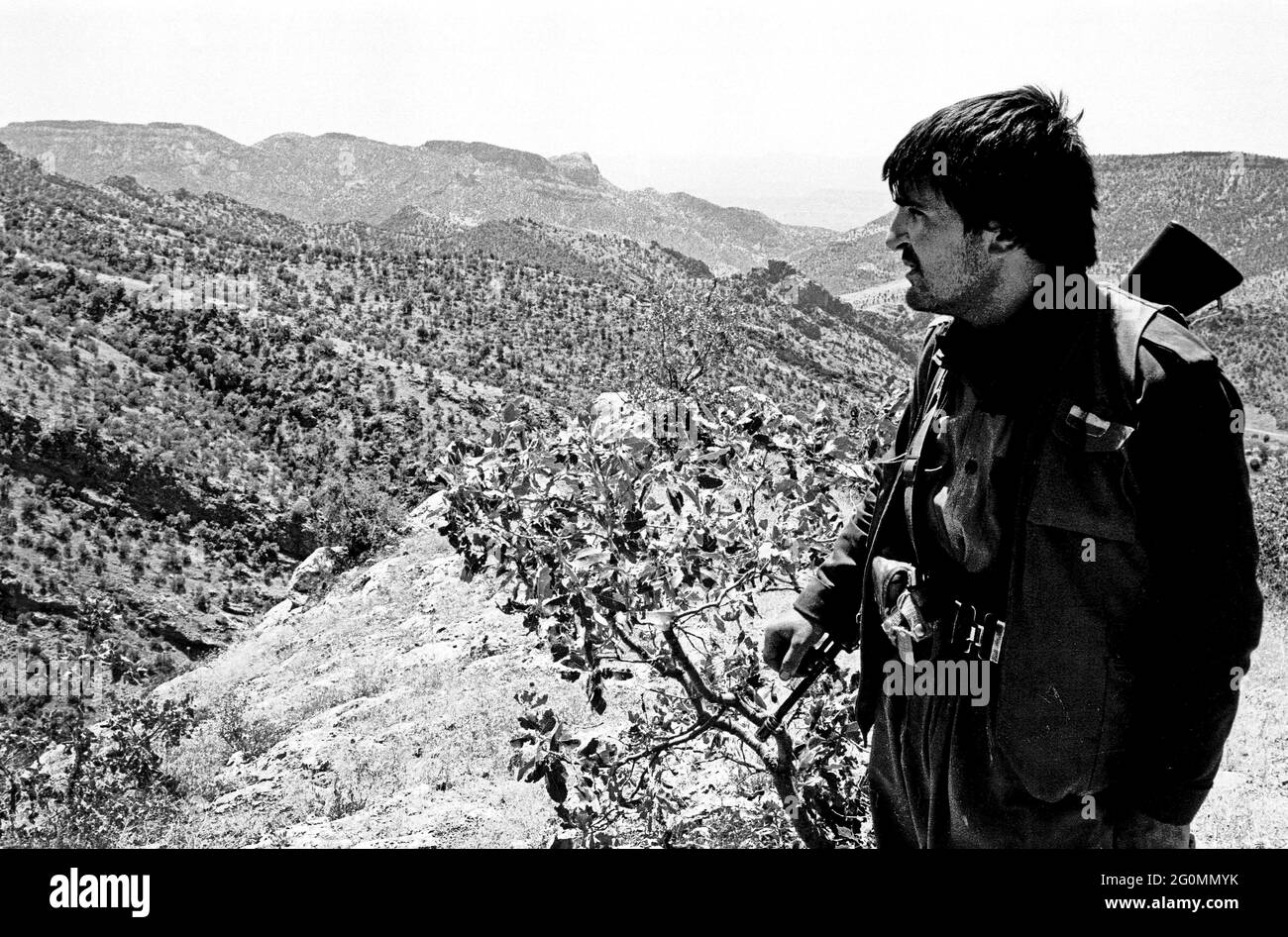 Nord de l'Irak, frontière avec la Turquie, Kurdistan. Juillet 1992. Un combattant du Parti des travailleurs du Kurdistan - PKK - regarde sur le terrain montagneux de la région pour laquelle il et ses compatriotes luttent pour l'autonomie. Banque D'Images