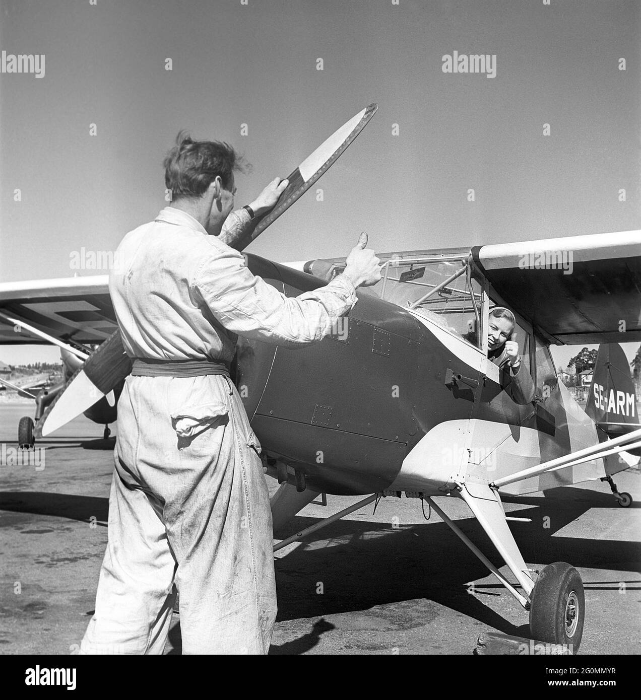 Femme pilote dans les années 1950 La seule serveuse de vol suédoise. RUT Berggren de Sundsvall a pris son certificat de vol dans un club d'avion de Stockholm et est vu ici dans le cockpit donnant les pouces jusqu'à un mécanicien avant un vol. Suède 1952. Réf. AY38-7 Banque D'Images