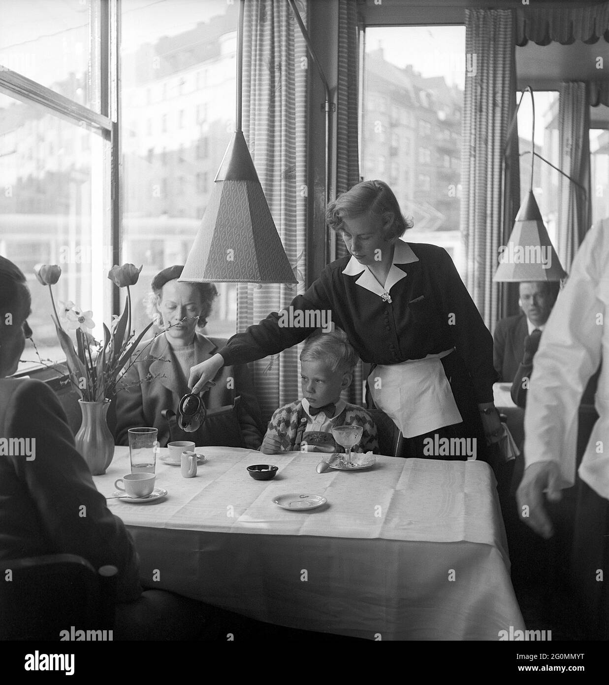 Travailler dans un restaurant dans les années 1950. La jeune rut Berggren travaille comme serveuse pour gagner assez d'argent pour prendre son certificat de vol. Photographié à son travail dans un restaurant de Stockholm servant du café. 1952 réf. AY45-12 Banque D'Images