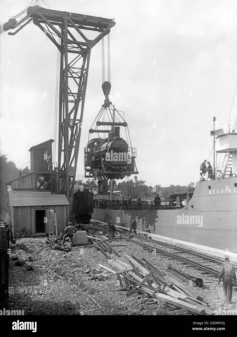 Exportation de locomotives dans les années 1920. La société suédoise Nydqvist & Holm était le plus grand fabricant de locomotives en Suède et elle en a fait 1000 1912. 1920 ils ont reçu de la Russie une commande de 1000 locomotives d'une valeur de 230 millions de couronnes suédoises, la plus grosse commande jusqu'alors. Le paiement a été effectué en barres d'or pour un poids de 56 tonnes. La photo montre l'une des locomotives chargées sur le navire britannique Neebing à Trollhättan comme l'une des 10 premières locomotives livrées en juillet 1922. Banque D'Images