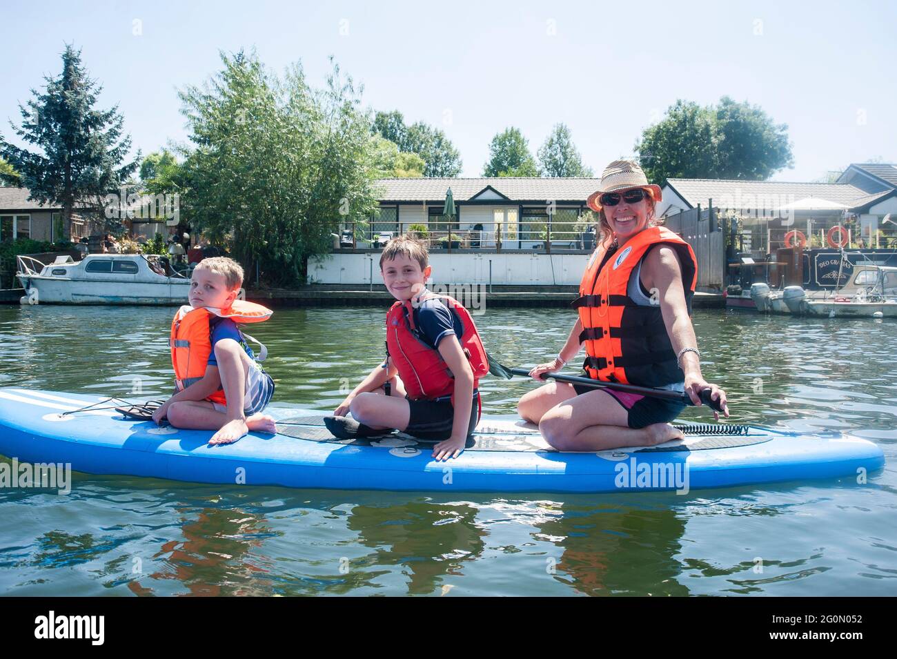 Un groupe d'amis qui s'amusent à paddler sur des kayaks et des sous-groupes sur la Tamise à Londres. Banque D'Images