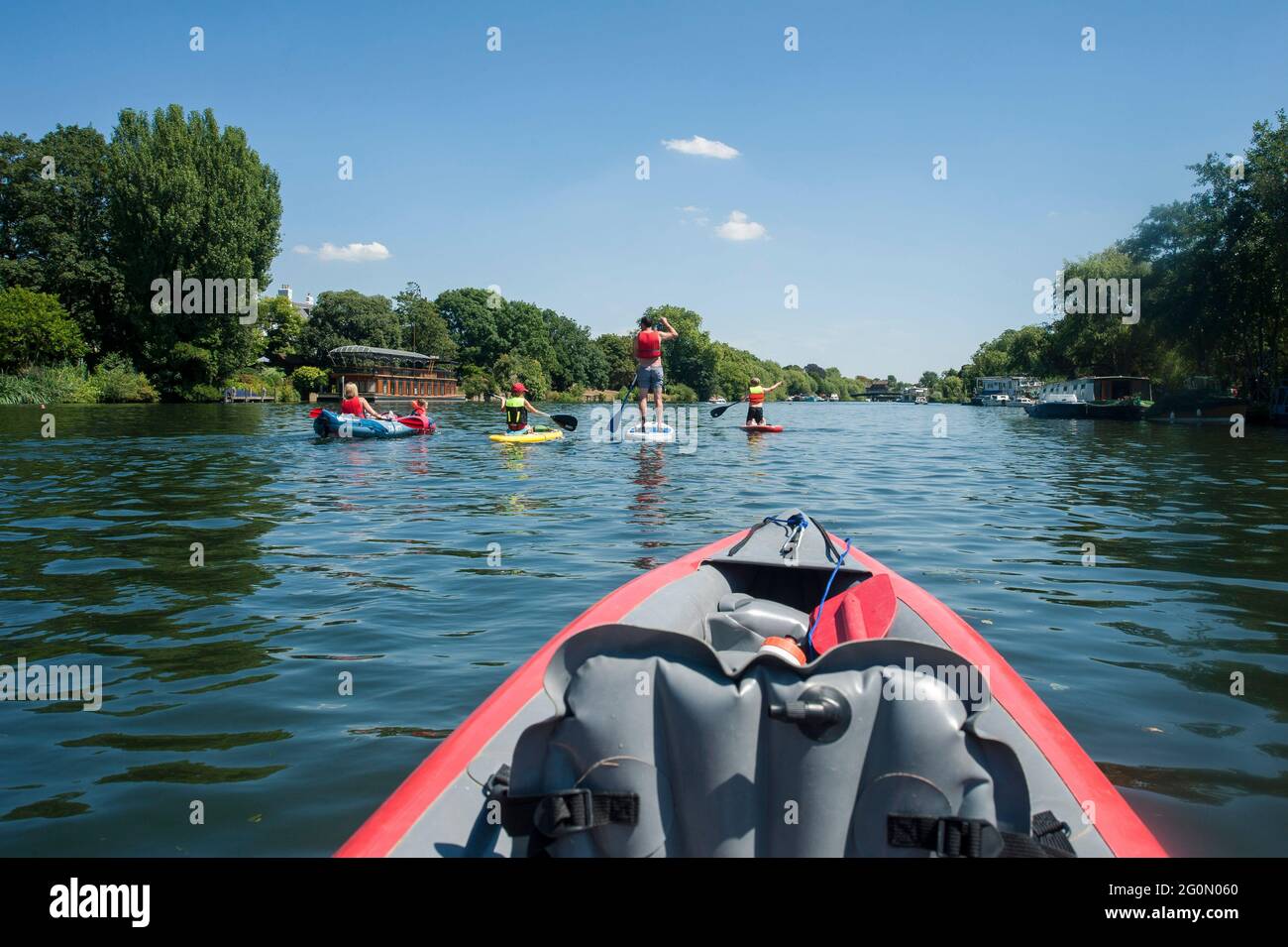 Un groupe d'amis qui s'amusent à paddler sur des kayaks et des sous-groupes sur la Tamise à Londres. Banque D'Images