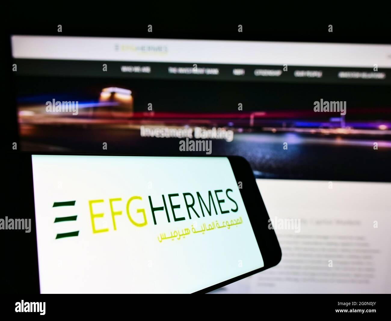 Smartphone avec logo de la société financière égyptienne EFG Hermes Holding S.A.E. sur écran en face de la page web. Effectuez la mise au point au centre-droit de l'écran du téléphone. Banque D'Images