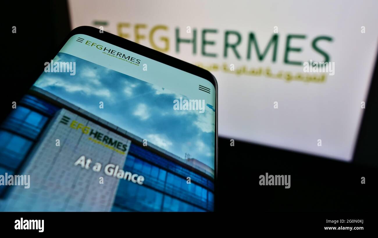 Téléphone portable avec le site web de la société financière égyptienne EFG Hermes Holding SAE sur l'écran devant le logo de l'entreprise. Faites la mise au point dans le coin supérieur gauche de l'écran du téléphone. Banque D'Images