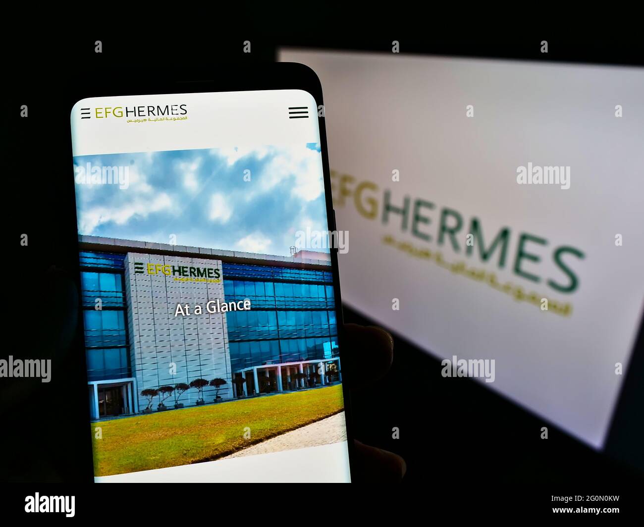 Personne tenant un téléphone mobile avec le site web de la société financière égyptienne EFG Hermes tenant SAE sur l'écran avec logo. Concentrez-vous sur le centre de l'écran du téléphone. Banque D'Images