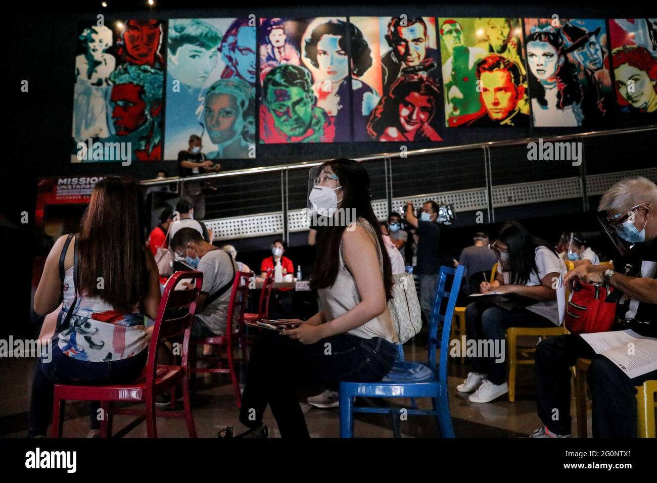 Les gens font la queue pour recevoir une dose du vaccin Sinovac COVID-19 à l'intérieur d'une salle de cinéma dans un centre commercial de San Juan City, dans la région métropolitaine de Manille, aux Philippines. Banque D'Images