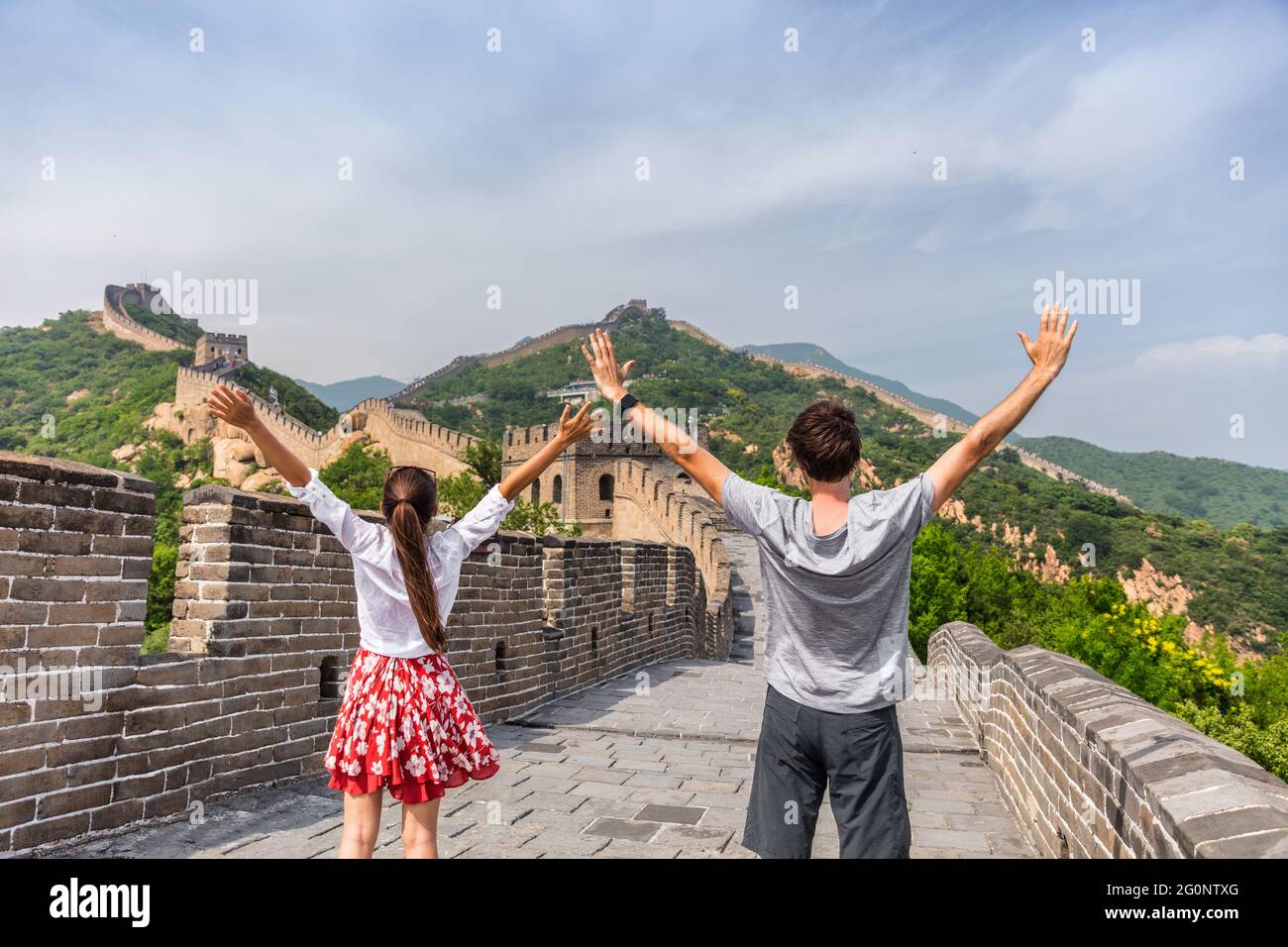 La Chine voyage à la Grande Muraille. Couple de touristes heureux acclamations en Asie sur la célèbre attraction touristique chinoise à Pékin. Jeunes avec les bras vers l'intérieur Banque D'Images