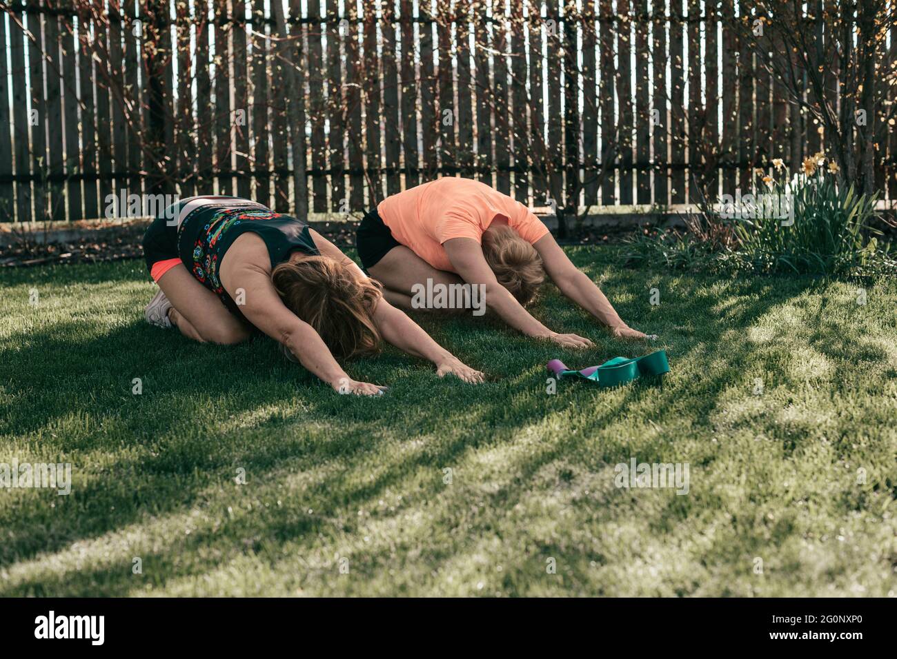 Les femmes âgées actives de 55-59 ans effectuent des exercices tout en étant allongées sur l'herbe Banque D'Images