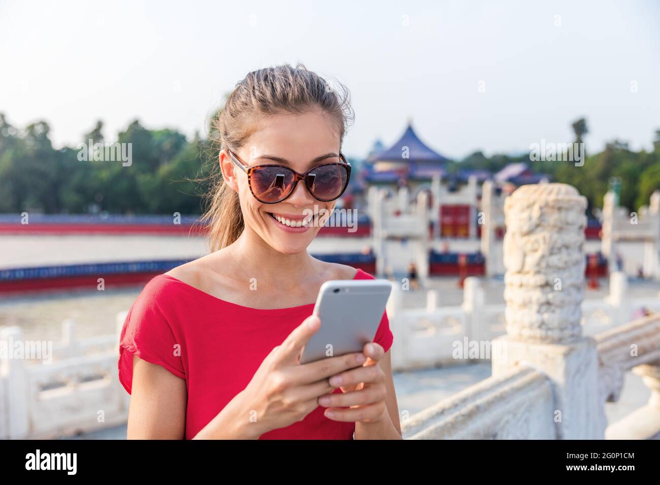 Touriste asiatique utilisant l'application de téléphone pour trouver un itinéraire et un guide pendant les voyages à Pékin, chine. Bonne femme chinoise qui envoie des SMS sur un smartphone mobile Banque D'Images