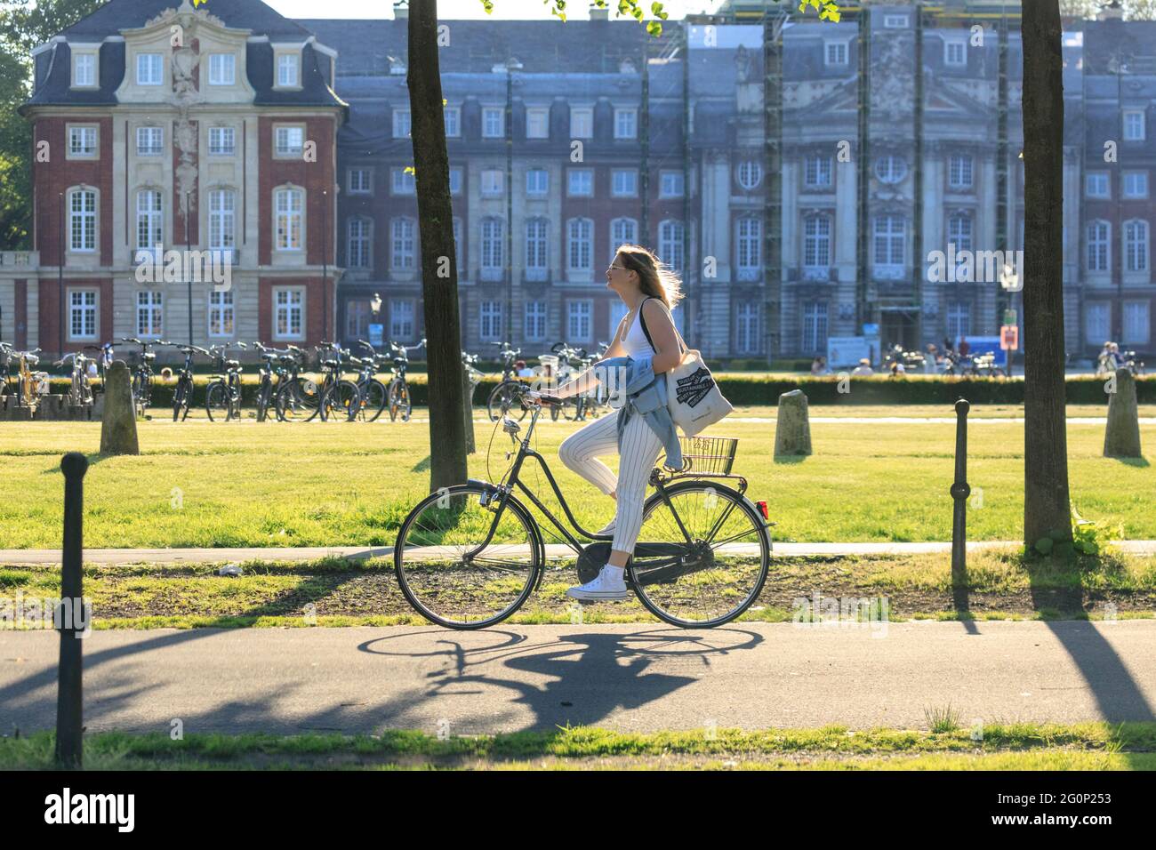 Münster, Allemagne. 2 juin 2021. Un cycliste passe devant Münster Schloss (palais de la ville) par une journée chaude et ensoleillée avec des températures autour de 28 degrés dans la ville universitaire de Münster. Le nombre de Covid a chuté régulièrement en Allemagne, ce qui a conduit à un assouplissement supplémentaire des restrictions. Münster se classe régulièrement parmi les villes les plus à incidence la plus faible de NRW. Credit: Imagetraceur/Alamy Live News Banque D'Images