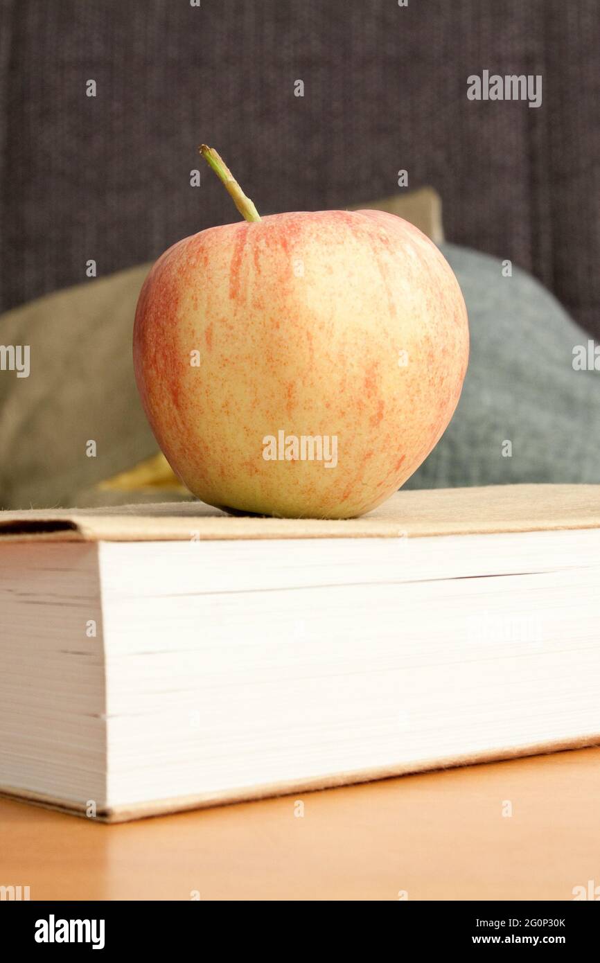 Photo verticale d'une pomme sur le livre dans la salle de lecture Banque D'Images