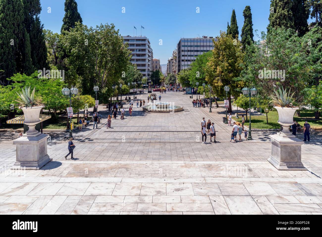 Athènes, Attique, Grèce. Place Syntagma au centre de la ville d'Athènes à l'heure de pointe pleine de personnes marchant ou se reposant sur les bancs Banque D'Images