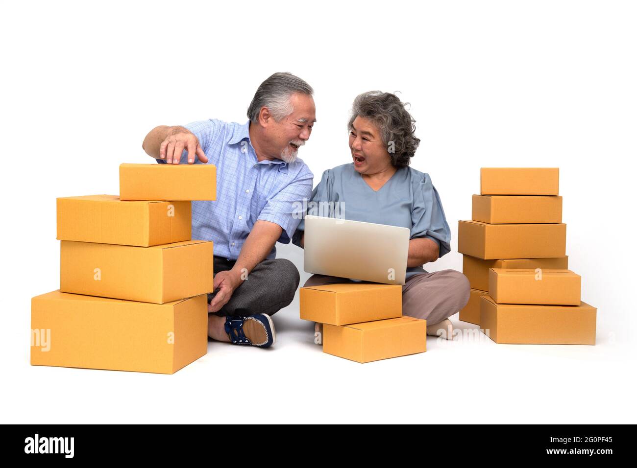 Senior asiatique couple démarrage petite entreprise freelance tenant boîte de colis et ordinateur portable et assis sur le sol isolé sur fond blanc, en ligne Banque D'Images