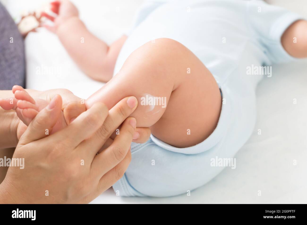 La Mere Applique De La Creme Au Bebe Garcon Qui Aide A Maintenir L Hydratation De La Peau Des Jambes Les Soins De La Peau Et Le Concept De Creme Hydratante Photo Stock