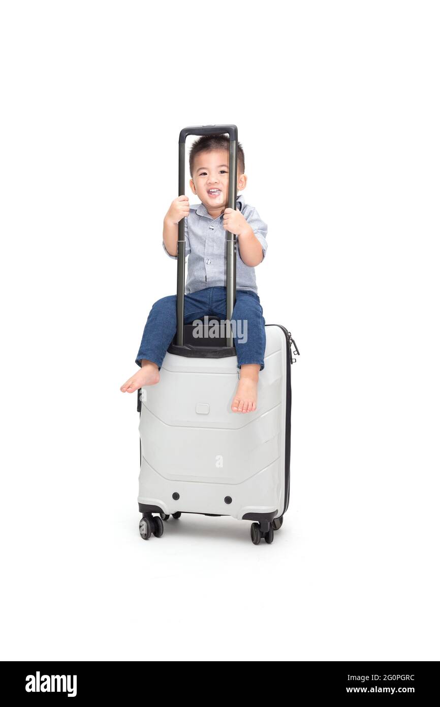 Happy Asian baby boy sitting sac de voyage ou une valise isolé sur fond blanc, les voyages et de nouvelles aventures voyage en famille pour enfants concept Banque D'Images