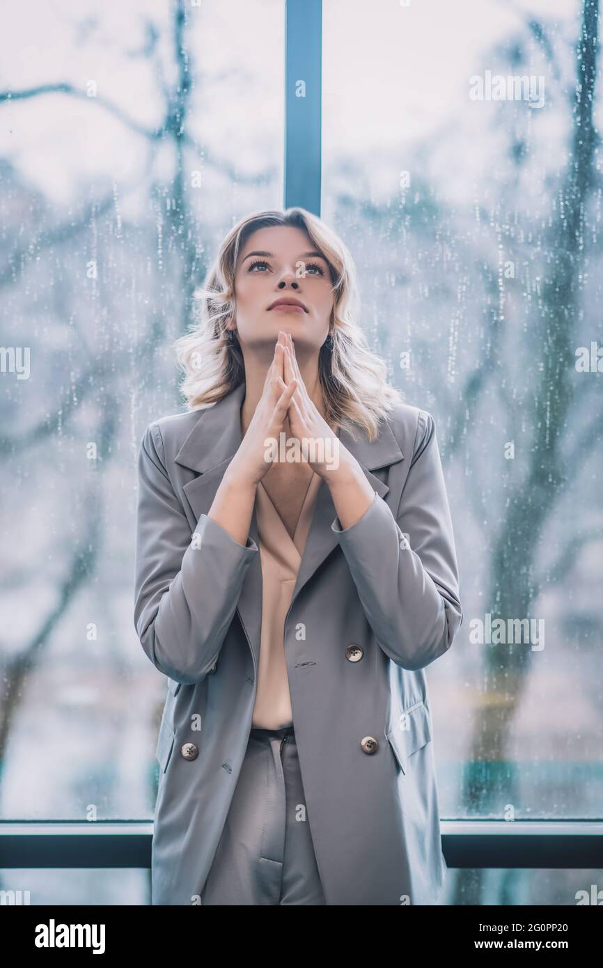 Femme pensive tenant les paumes fermées près du menton Banque D'Images