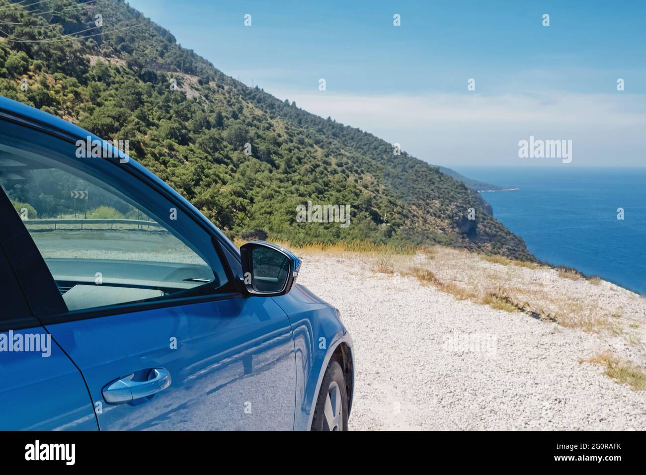 La voiture bleue s'est arrêtée près de la mer par beau temps Banque D'Images