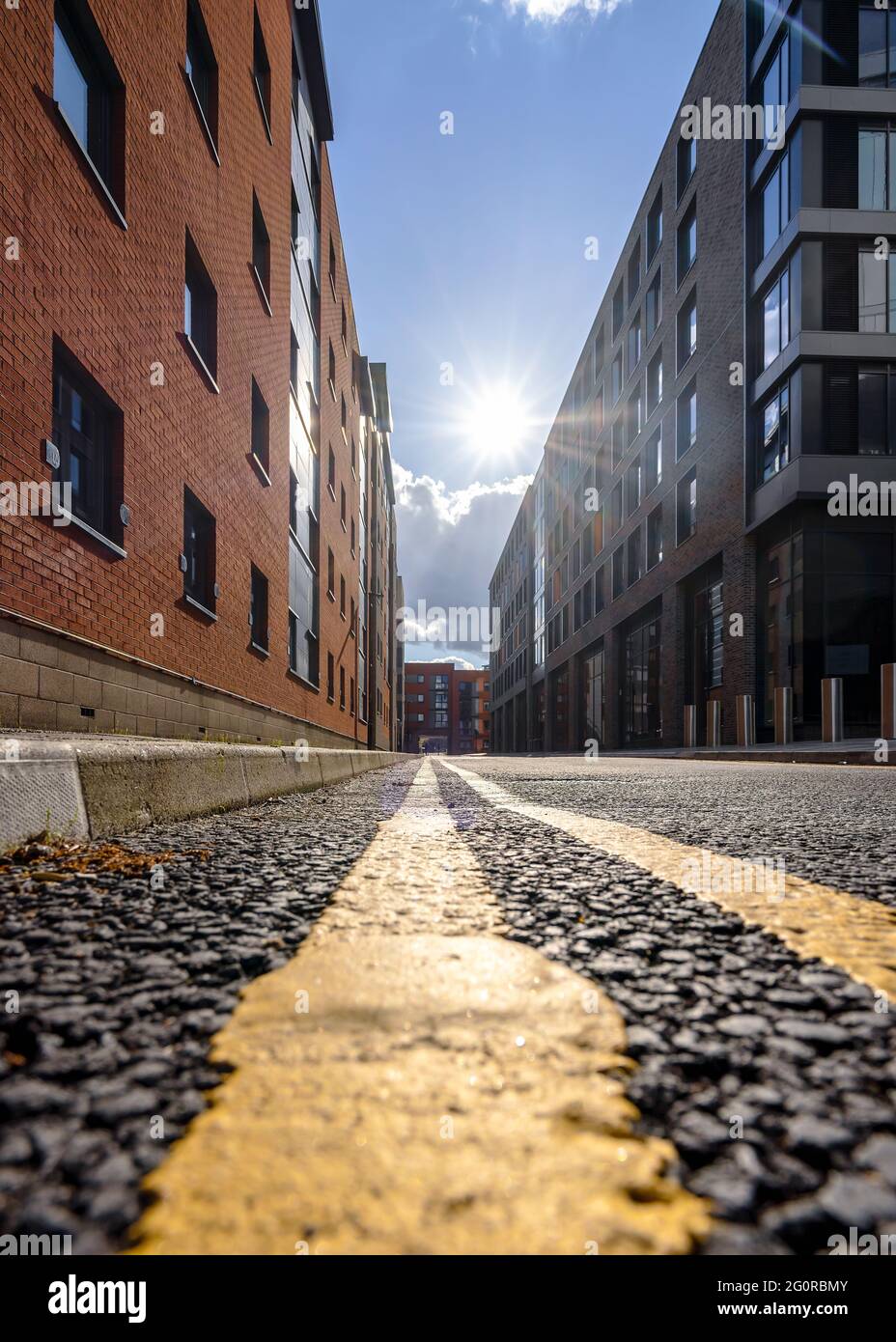 Lignes jaunes doubles sur une rue déserte. Restrictions de stationnement coucher de soleil sur la route du tarmac. Interdiction de stationner sur la chaussée. Banque D'Images