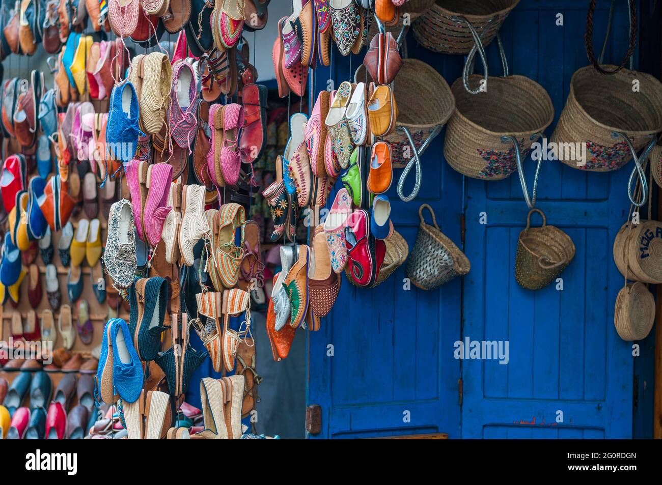 Des chaussures colorées sont accrochées devant un marché dans un souk. Banque D'Images