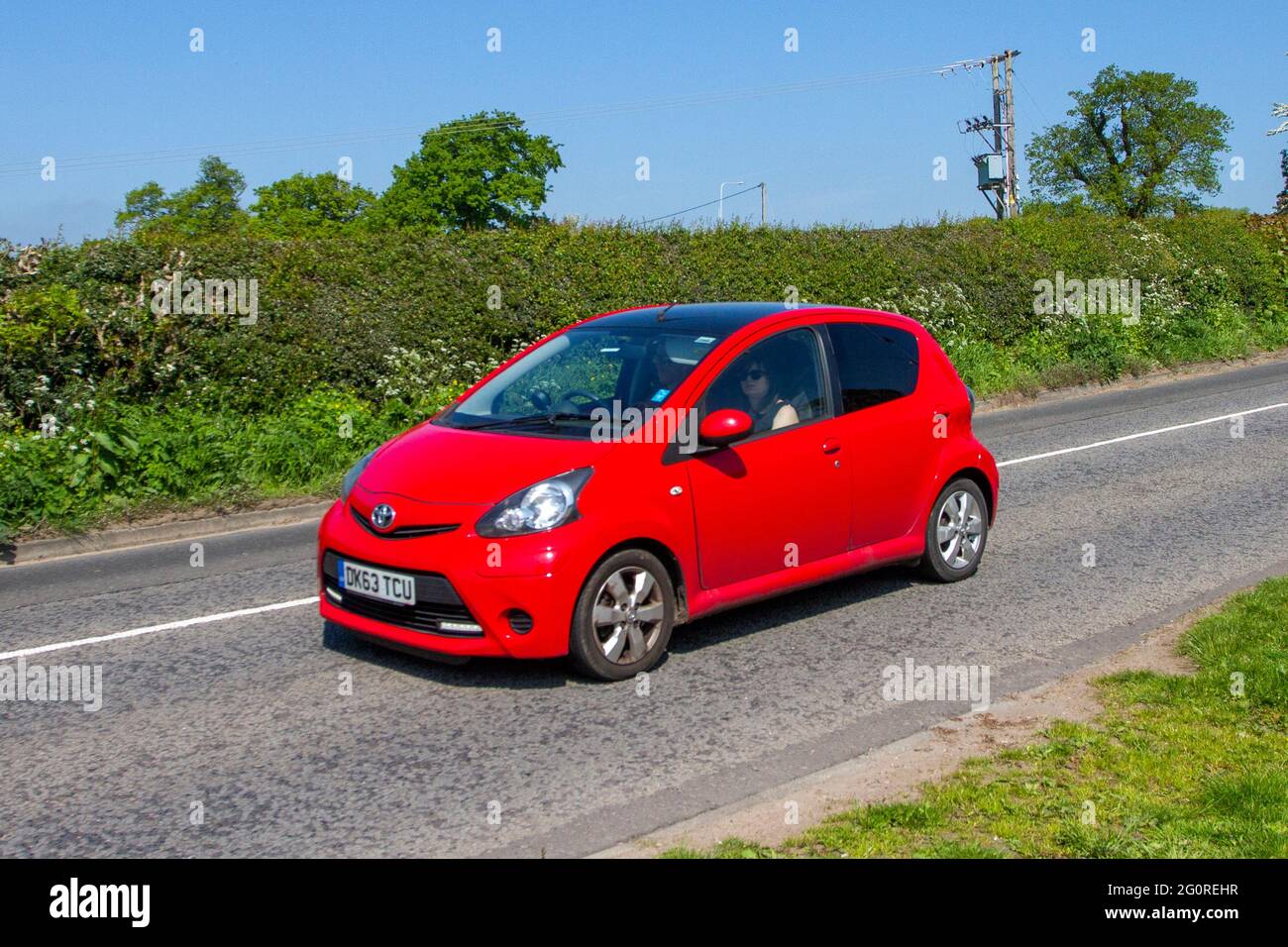 2013 rouge Toyota Aygo Move avec style VVT, 998cc essence hatchback en route vers Capesthorne Hall Classic May car show, Cheshire, Royaume-Uni Banque D'Images