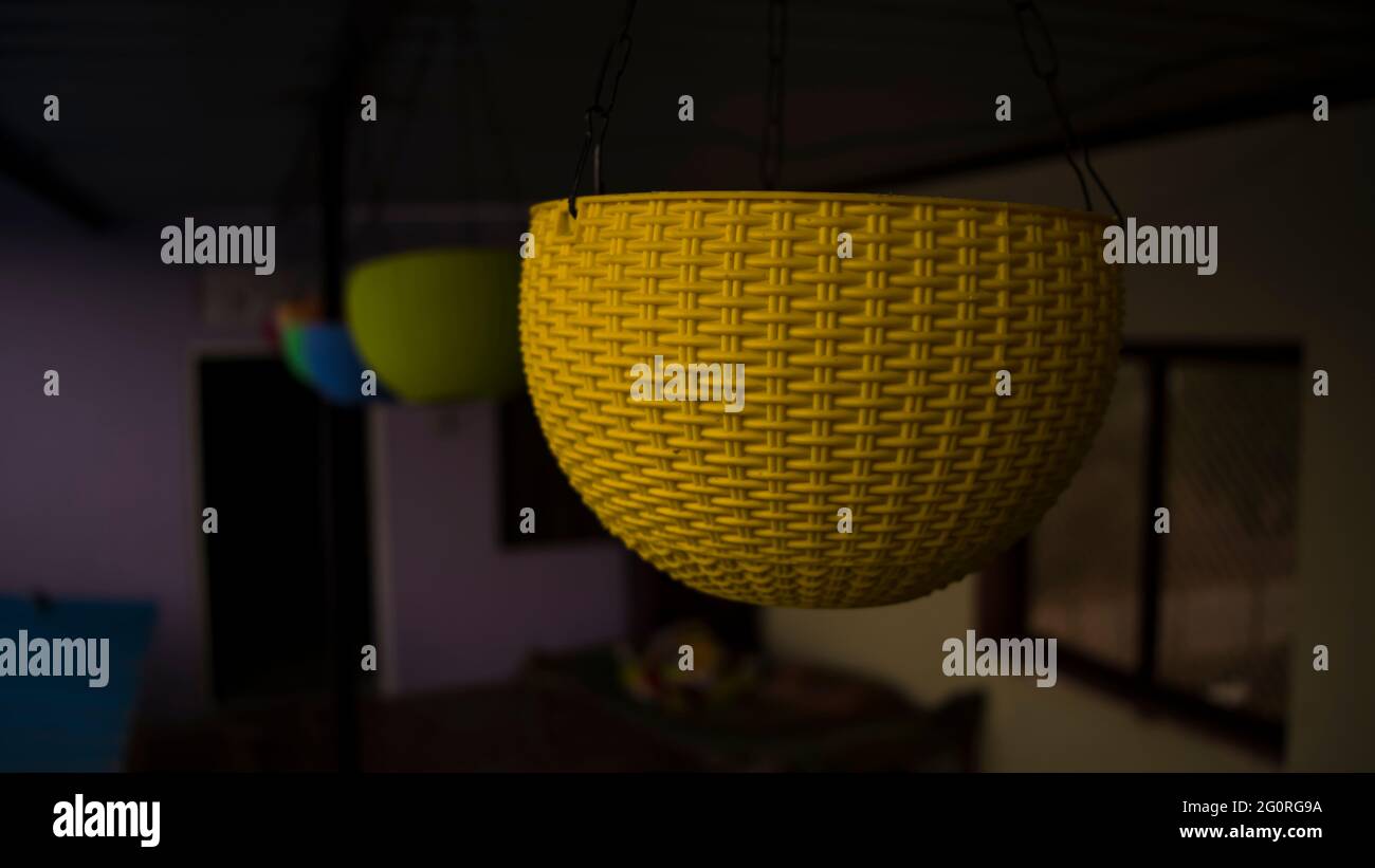 Superbe look avec pot de fleurs suspendu en plastique de différentes couleurs. Intérieur de la maison. En attendant l'été pour planter des fleurs Banque D'Images