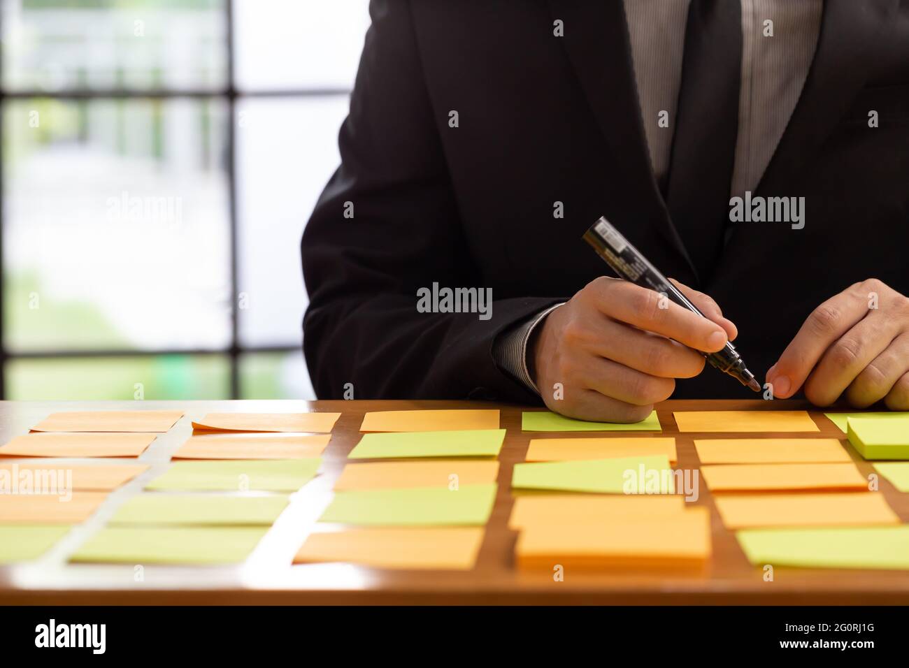 Travail de planification de l'homme d'affaires avec le pense-bête sur la table dans le bureau, le Scrum board et le concept de méthodologie agile Banque D'Images