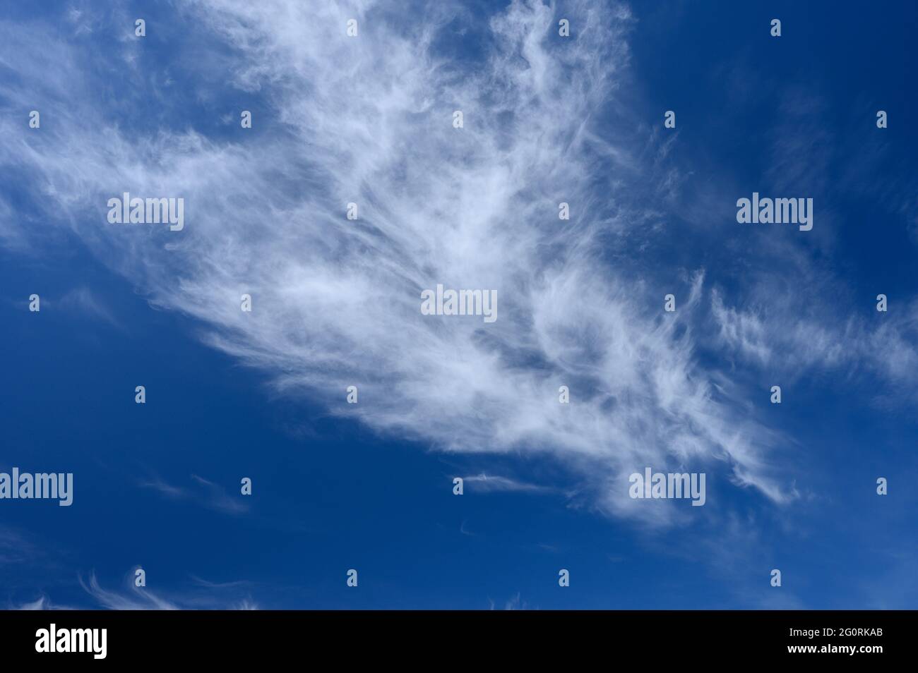 Le Cirrus s'agise contre un ciel bleu vif, tourné avec un filtre polarisant  Photo Stock - Alamy