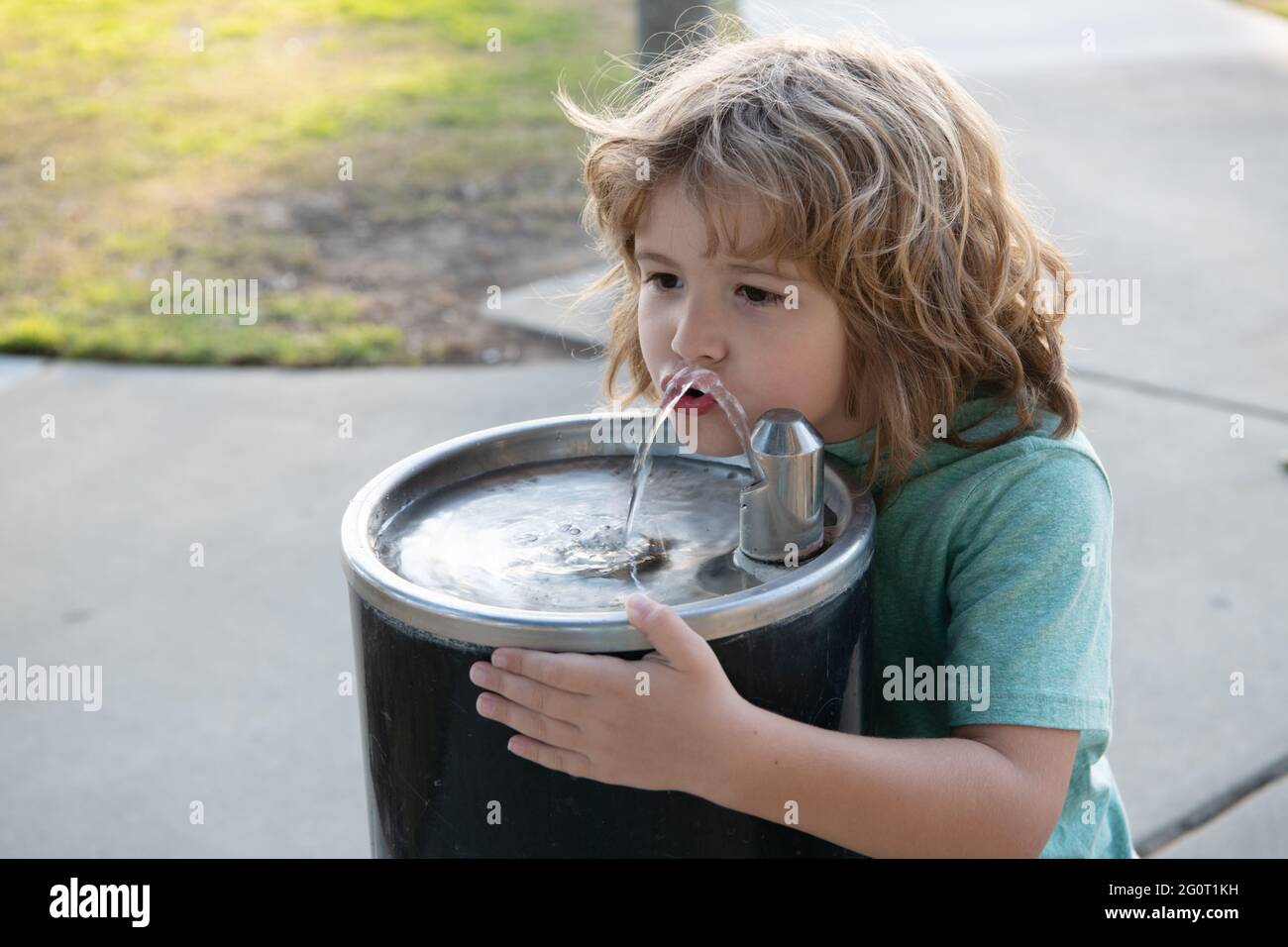 Solution de rafraîchissement. Un enfant assoiffé boit de l'eau de la fontaine. Soif désaltérante Banque D'Images