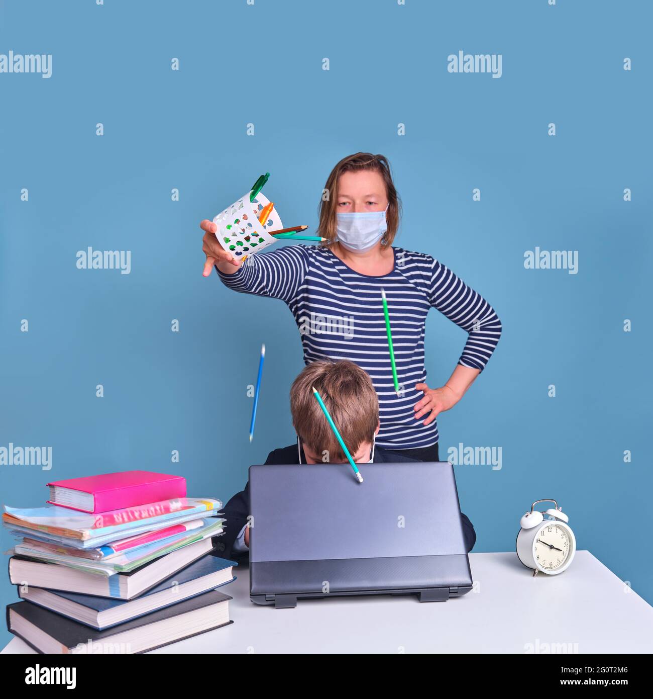 Drôle de jeune garçon dans l'uniforme d'école à son bureau avec ordinateur portable, des problèmes d'apprentissage à distance en raison du coronavirus Banque D'Images