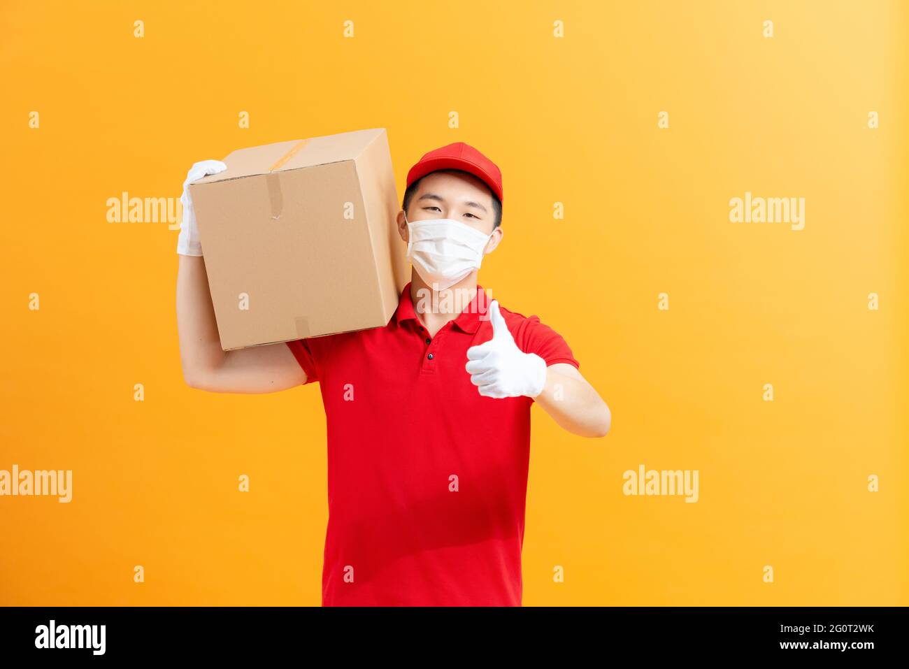 Livraison en toute sécurité. Femme Courier dans masque de protection du visage et gants avec boîte en carton. Concept anti-coronavirus. Banque D'Images