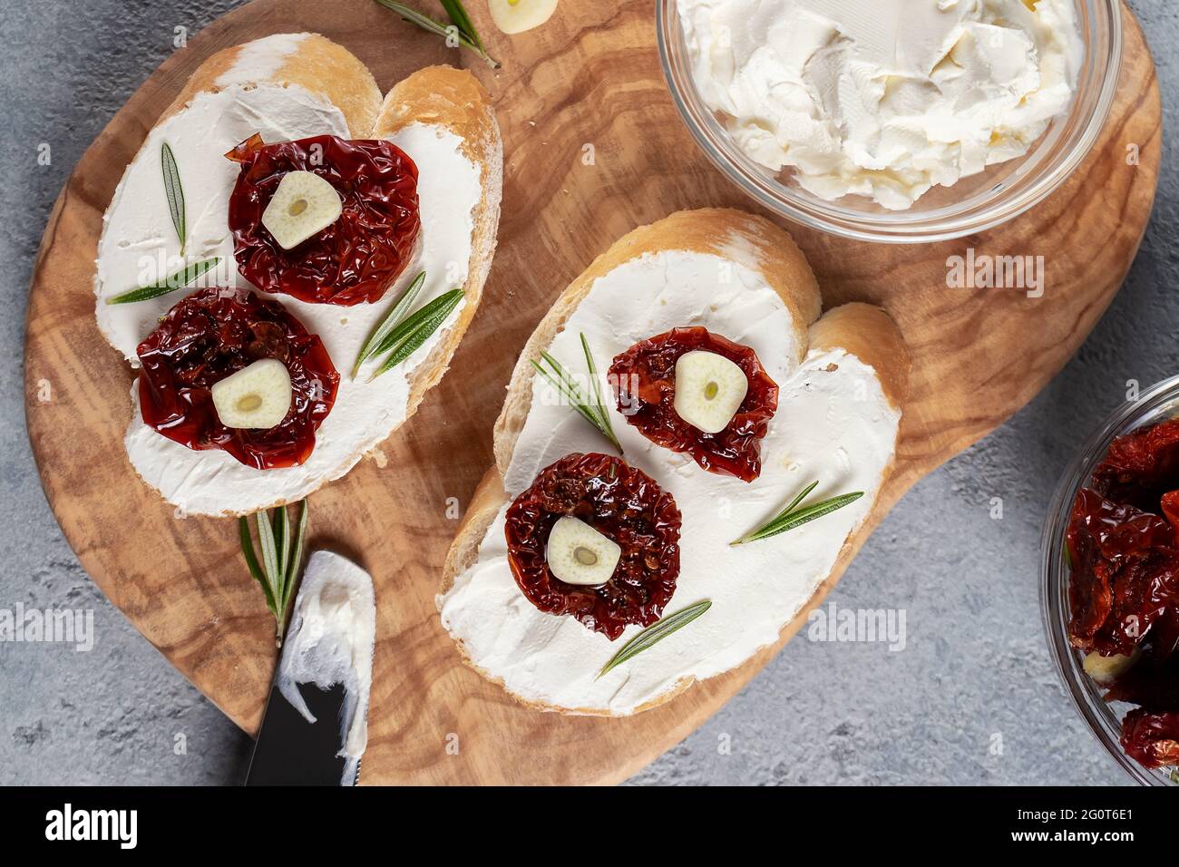 Sandwiches maison avec fromage à la crème et tomates séchées sur un plateau d'olive - délicieux petit déjeuner sain, cuisine italienne, plat. Banque D'Images