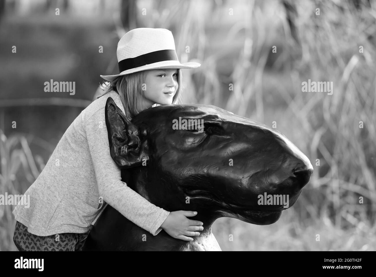 JOHANNESBURG, AFRIQUE DU SUD - 05 janvier 2021: Johannesburg, Afrique du Sud, 05/10/2014, jeune fille embrassant une sculpture de chien à la Foire de Sculpture d'hiver Banque D'Images