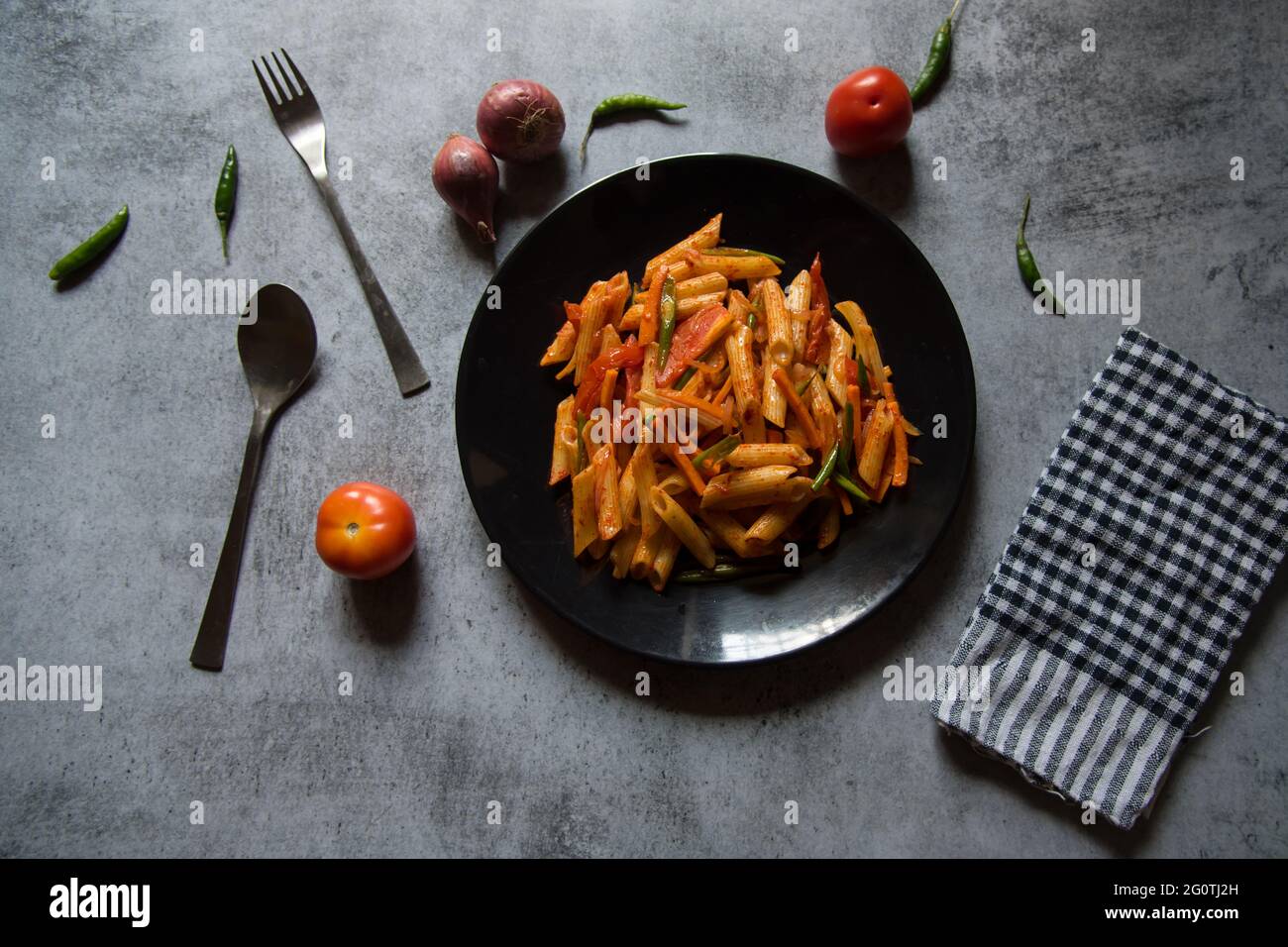 Pâtes alimentaires italiennes avec sauce tomate sur une assiette noire. Vue de dessus. Banque D'Images