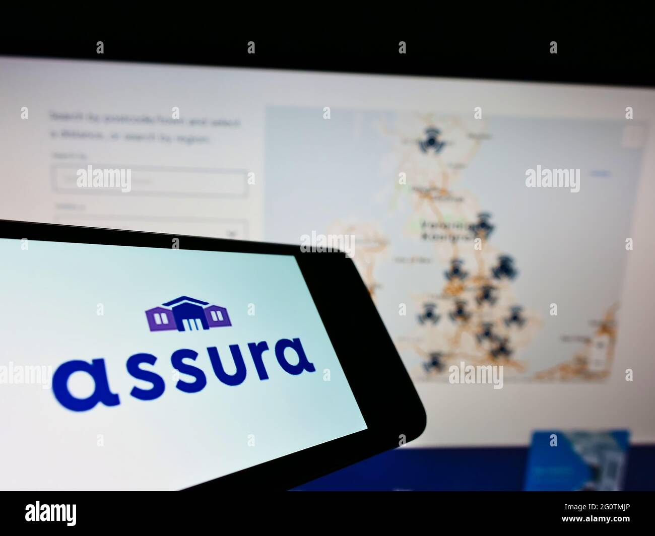 Smartphone avec logo de la société immobilière britannique Assura plc sur écran devant le site Web des entreprises. Effectuez la mise au point au centre-droit de l'écran du téléphone. Banque D'Images