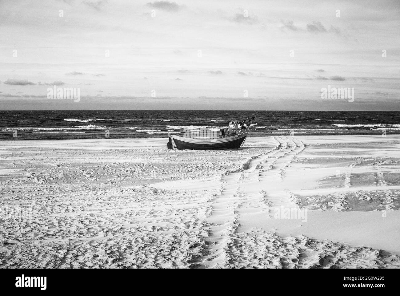 Bateaux de pêche sur la côte de l'Osstsee sur la plage en Pologne dans un aspect noir et blanc mélancolique. Plage sur la mer Baltique avec bateaux de pêche. Banque D'Images