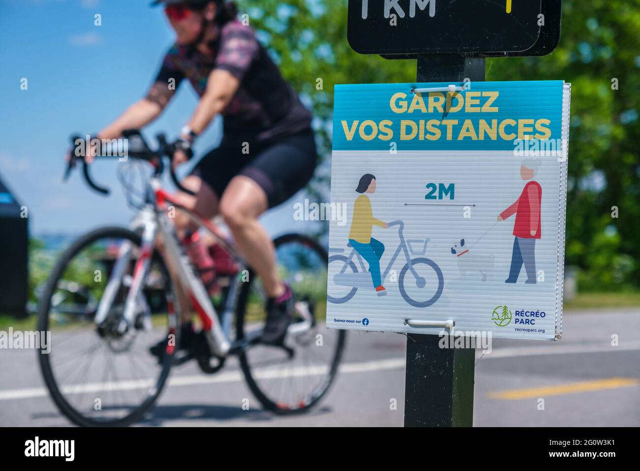 Sainte-Catherine, CA - 3 mai 2021 : deux personnes marchant à côté d'un panneau indiquant les directives de sécurité de french Covid-19 à Recreoparc Banque D'Images