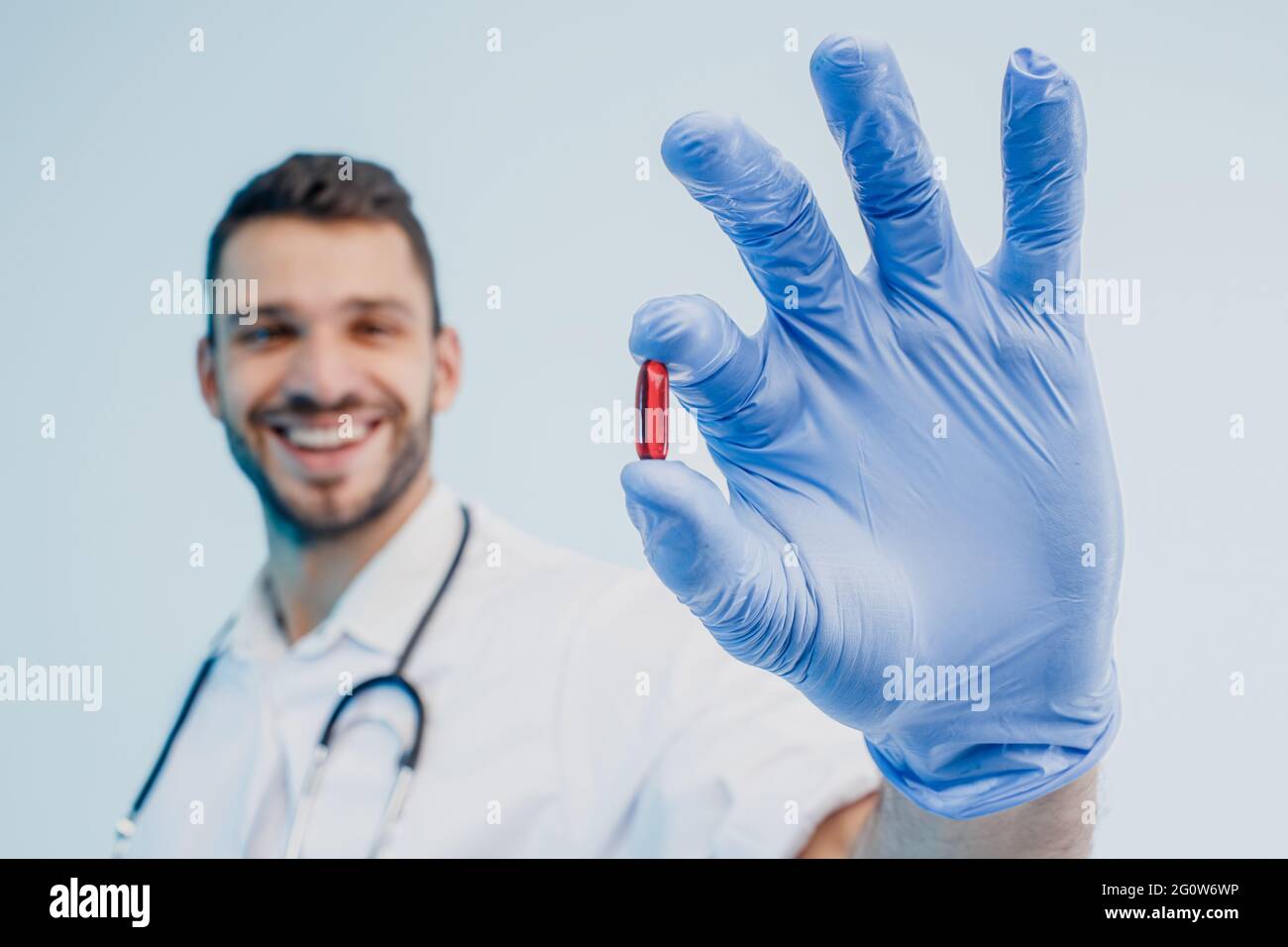 Un médecin européen souriant montrant une pilule médicale Banque D'Images