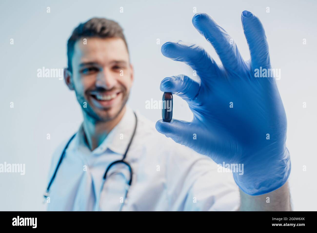 Un médecin européen souriant montrant une pilule médicale Banque D'Images