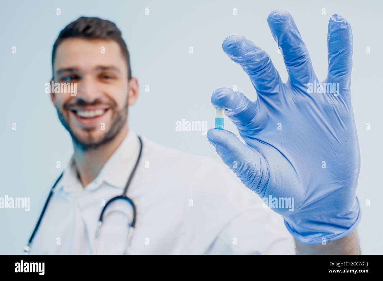 Un médecin européen souriant montrant une pilule médicale Banque D'Images