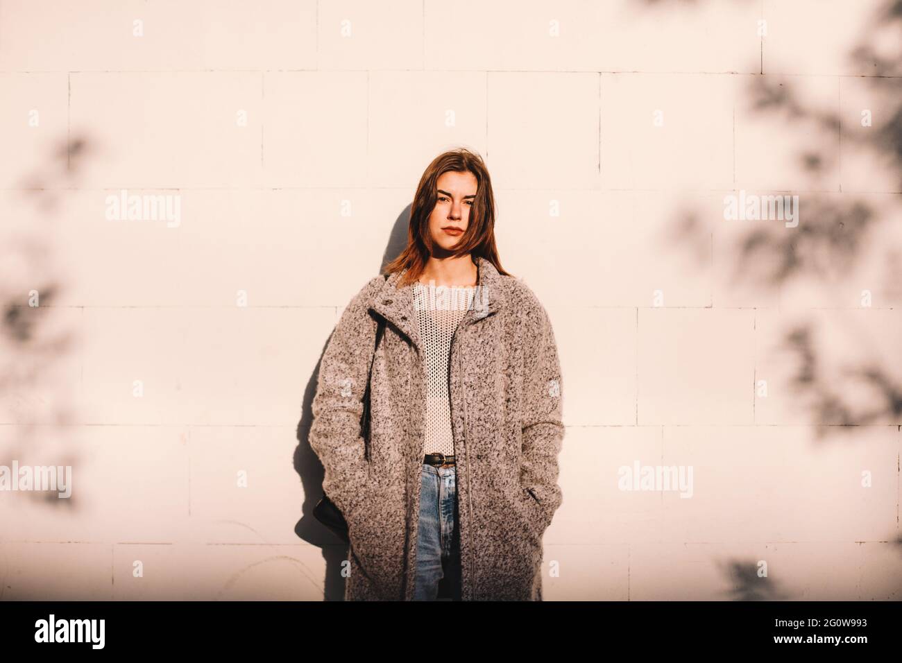 Portrait d'une femme transgenre debout contre un mur en ville Banque D'Images