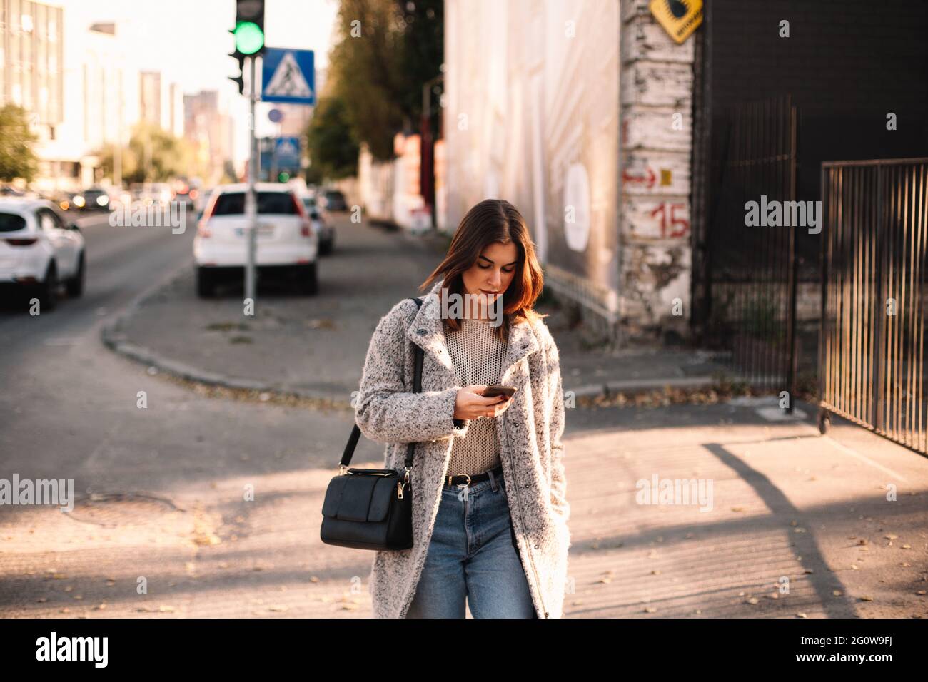 Femme non binaire utilisant un smartphone lors de ses déplacements en ville Banque D'Images