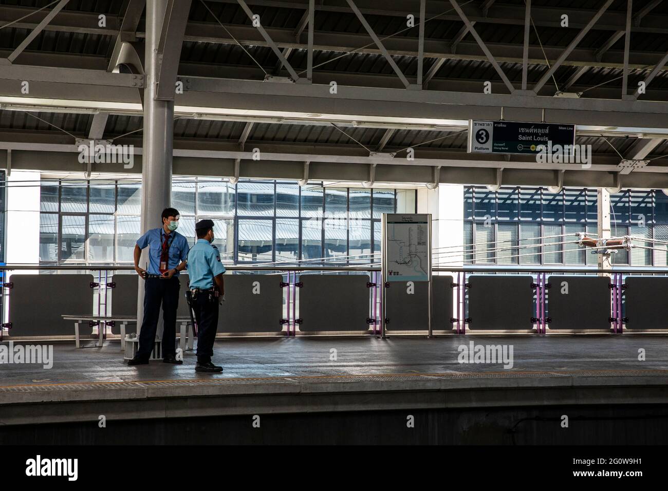 Deux gardes de sécurité regardent au-dessus D'UNE station SkyTrain déserte par Covid Banque D'Images