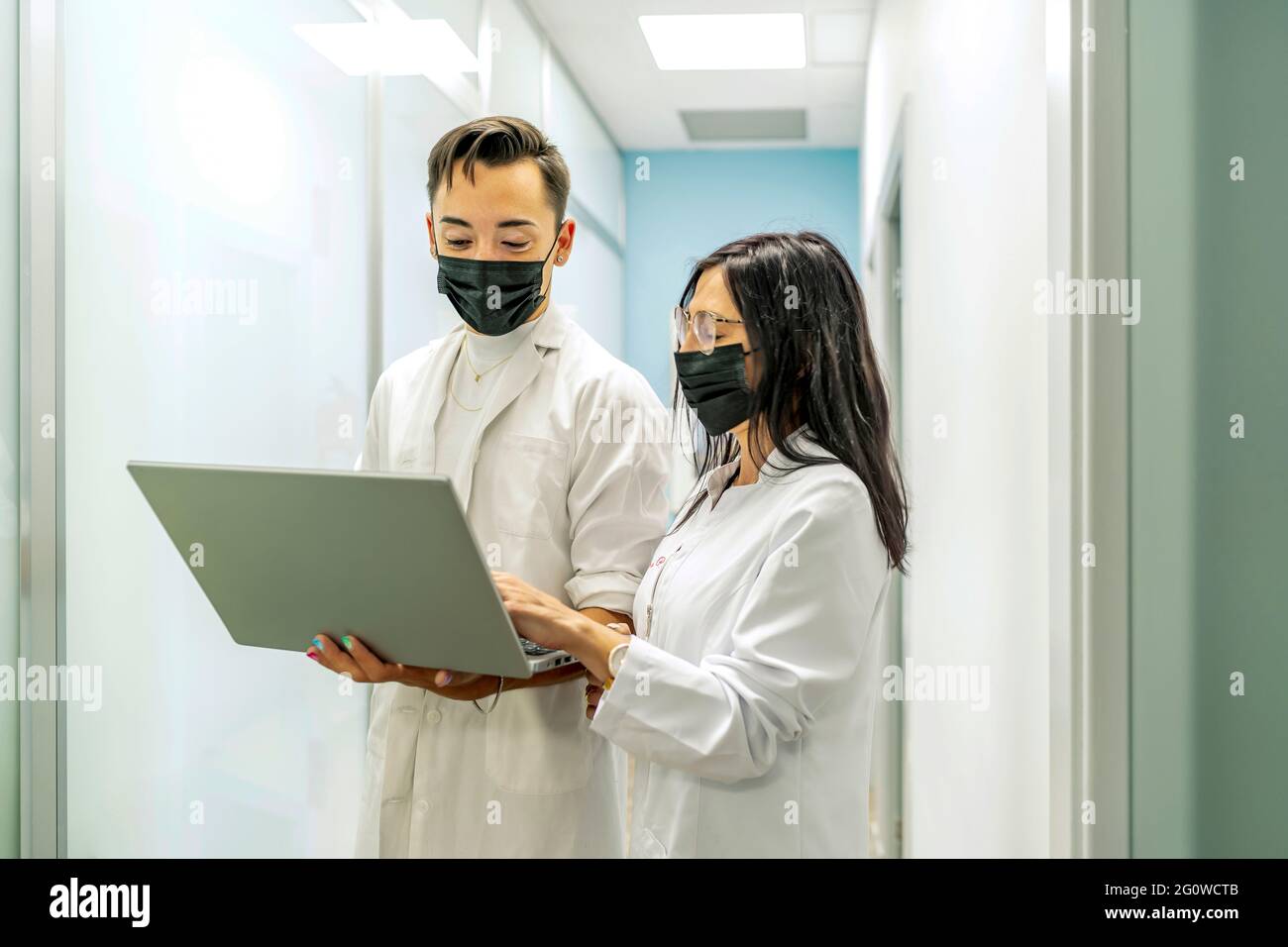 médecins consultant l'ordinateur portable pour voir un rapport Banque D'Images