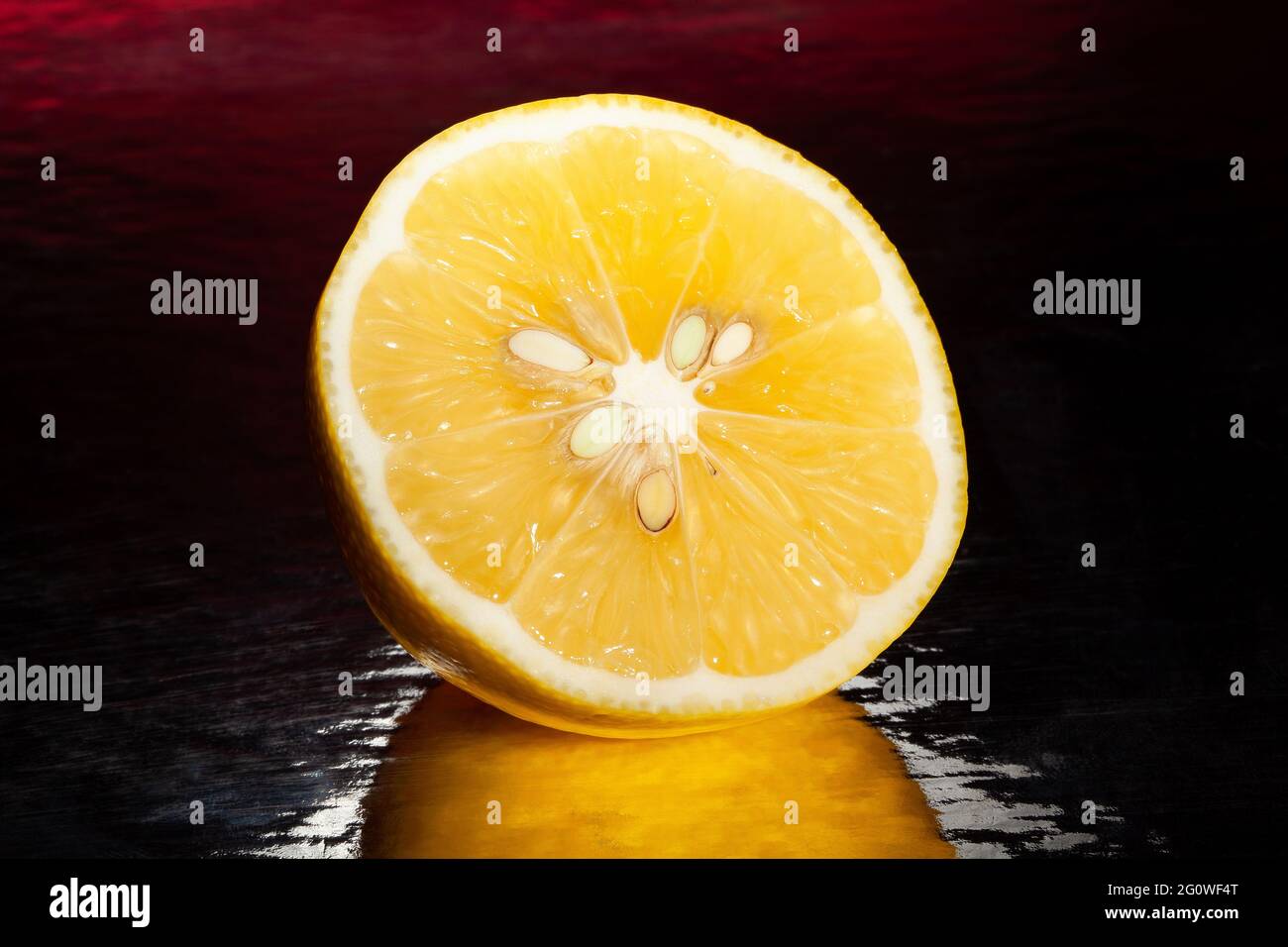citron en tranches sur fond réfléchissant noir Banque D'Images