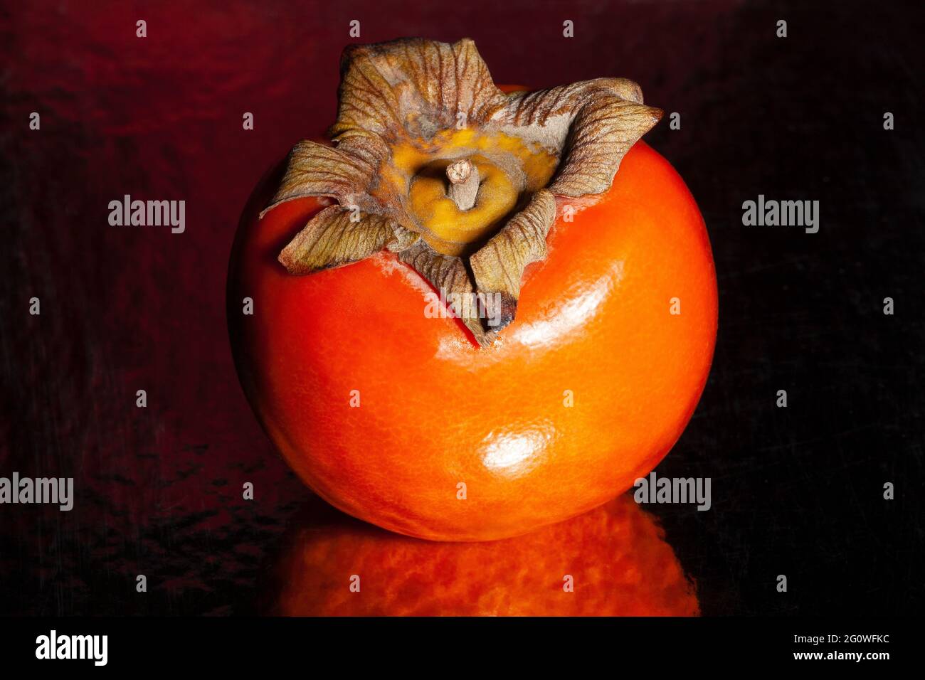 persimmon sur fond réfléchissant noir Banque D'Images