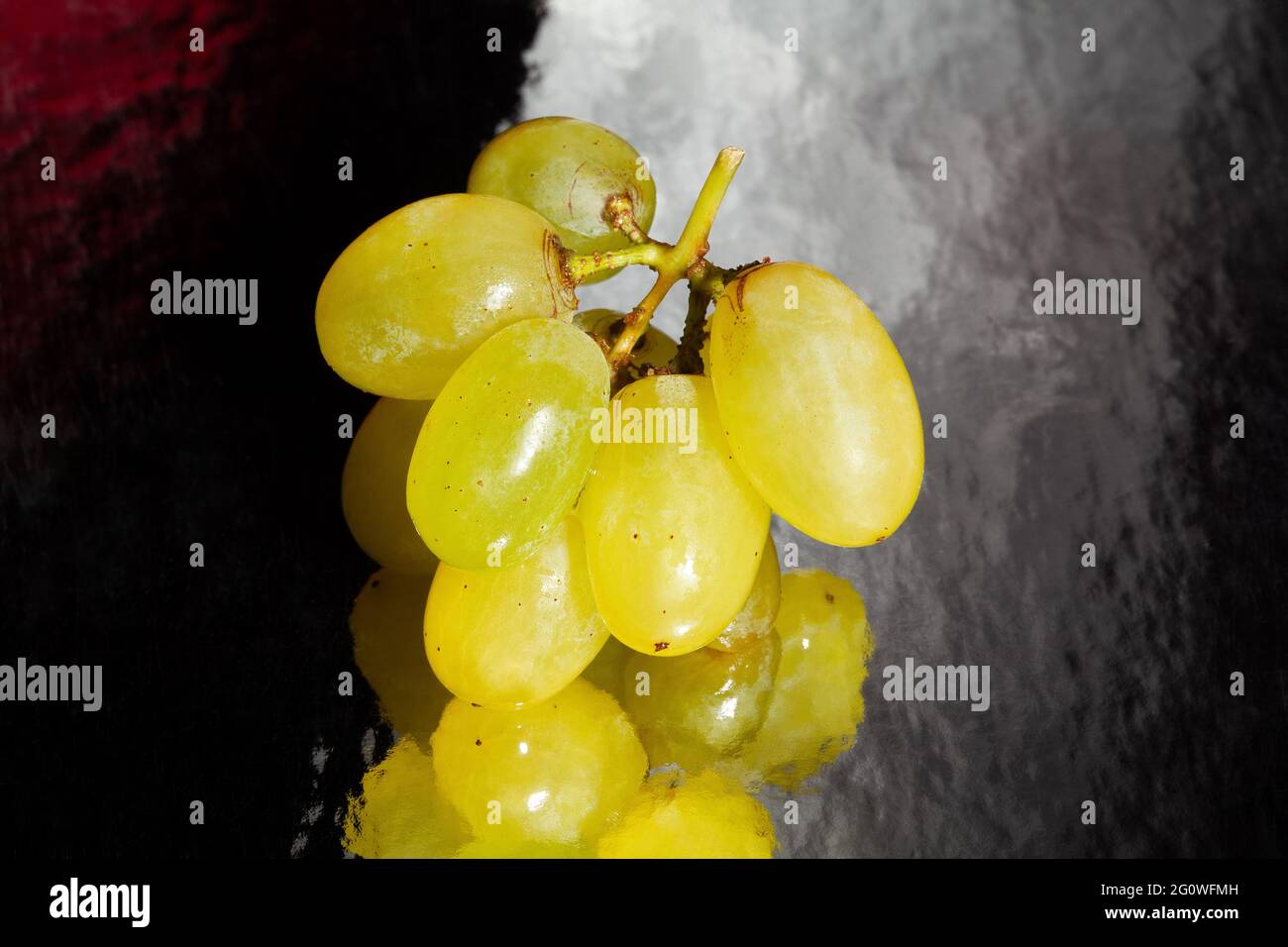 raisin blanc sur fond réfléchissant noir Banque D'Images