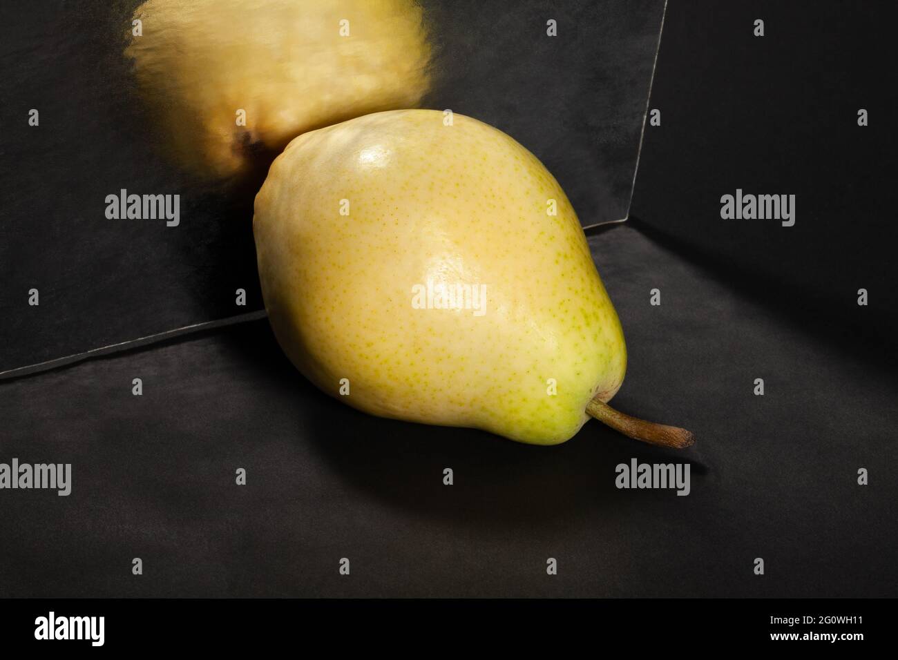 poire jaune symétrique sur fond noir Banque D'Images