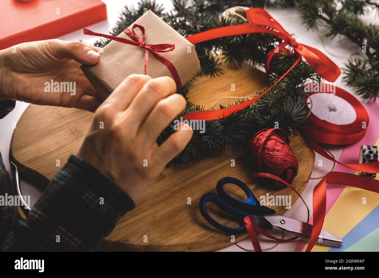 Femme faisant cadeau de noël à table. Décoration de noël faite maison et cadeau. Arrière-plan de Noël. Banque D'Images