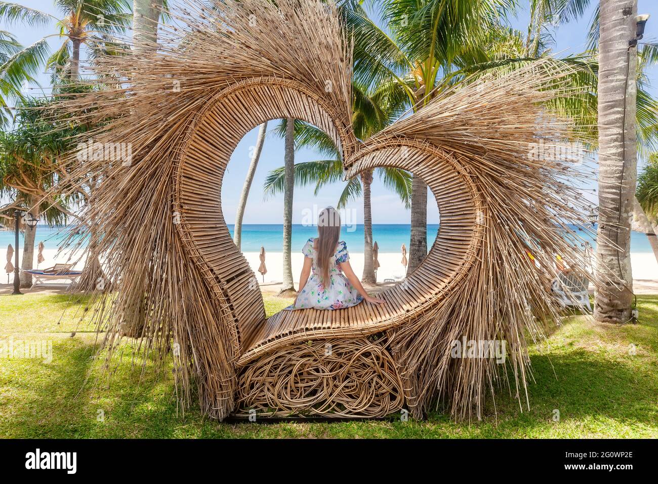 Vue arrière de la femme de tourisme assis dans un coin photo comme Coeur de paille avec palmier Banque D'Images