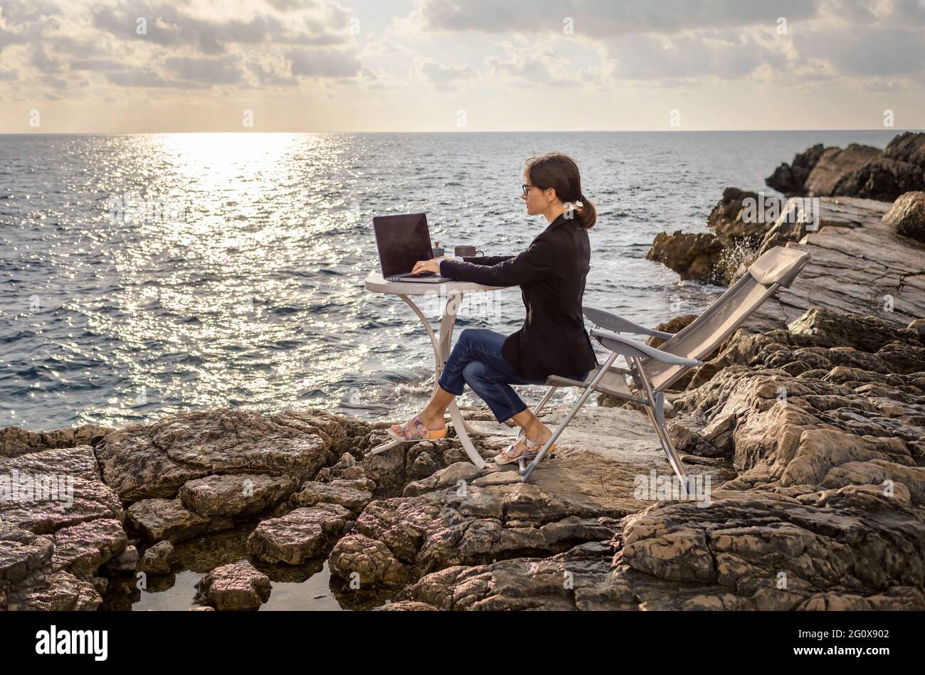 Femme d'affaires travaillant de la plage. Concept de travail à distance. Les indépendants voyagent et travaillent en ligne. Banque D'Images